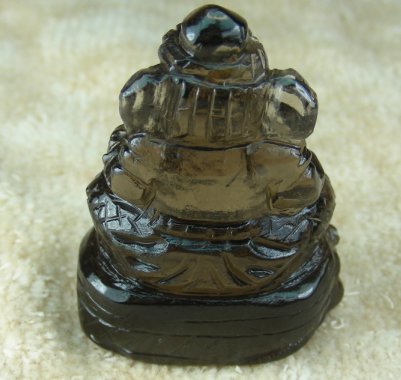 พระพิฆเนศ แกะสลักจากพลอยสโมกกี้ หนัก 92.36 กะรัต ขนาด สูง 3.7cm กว้าง 2.4 cm สีควันบุหรี่ ทำจากพลอยแท้ทั้งก้อน Hand Made ช่างจันทบุรี