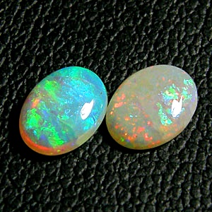 โอปอล Opal ออสเตรเลีย รูปไข่หลังเบี้ยคู่ 2 เม็ด หนัก 1,57 กะรัต ขนาด 8x6 มิล พื้นสีขาวบริสุทธิ์ เหลือบสีรุ้งชัดเจนและสวยมากแม้อยู่ในที่ร่ม ผิวเนียน