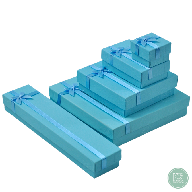 กล่องกระดาษขนาด 10x10x3.5 cm มีโบว์สีฟ้า ใส่เครื่องประดับ ภายในมีฟองน้ำบุผ้ากำมะหยี่ จัดวาง แหวน ต่าง สร้อย มอบเป็นของ