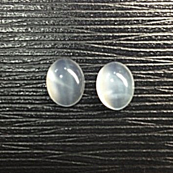 Moonstone (Cat's Eye) พลอยมูนสโตน แคทอาย รูปไข่หลังเบี้ยคู่ น้ำหนักรวม 5.03 กะรัต พื้นสีขาวขุ่น ถ้านำไปอยู่กลางแดดหรือแสงไฟ จะเห็นแคทอายพาดกลางเม็ด