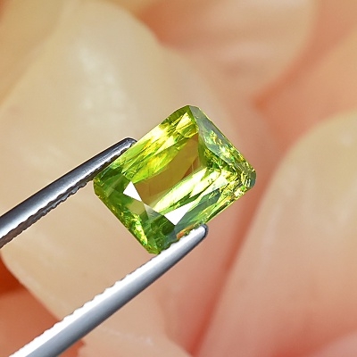 สฟีน SPHENE หรือ Titanite ไททาไนท์ รูปสี่เหลี่ยมตัดมุม น้ำหนัก 3.07 กะรัตพื้นสีเป็นสีเหลือง มีประกายรุ้ง ความสะอาดมองด้วยตาเปล่าสะอาด 90%-95%