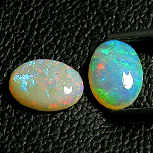โอปอล Opal ออสเตรเลีย รูปไข่หลังเบี้ยคู่ 2 เม็ด หนัก 1,57 กะรัต ขนาด 8x6 มิล พื้นสีขาวบริสุทธิ์ เหลือบสีรุ้งชัดเจนและสวยมากแม้อยู่ในที่ร่ม ผิวเนียน