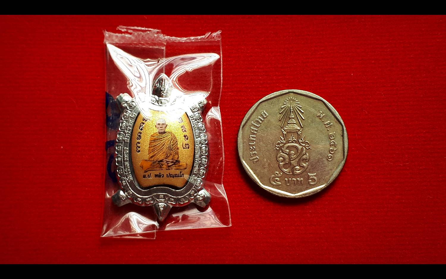 เหรียญ ล็อกเก็ต หลวงปู่หลิว วัดไร่แตงทอง เนื้อดีบุก ฉากหลังสีทอง ด้านหลังมีจิ้กจกและกัณหาชาลี (ขนาดจิ๋ว เม็ดแตง) (บรรจุฝัง เกศา อัฐิ หลวงปู่หลิว และ มวลสารอื่นๆ) ปี2560