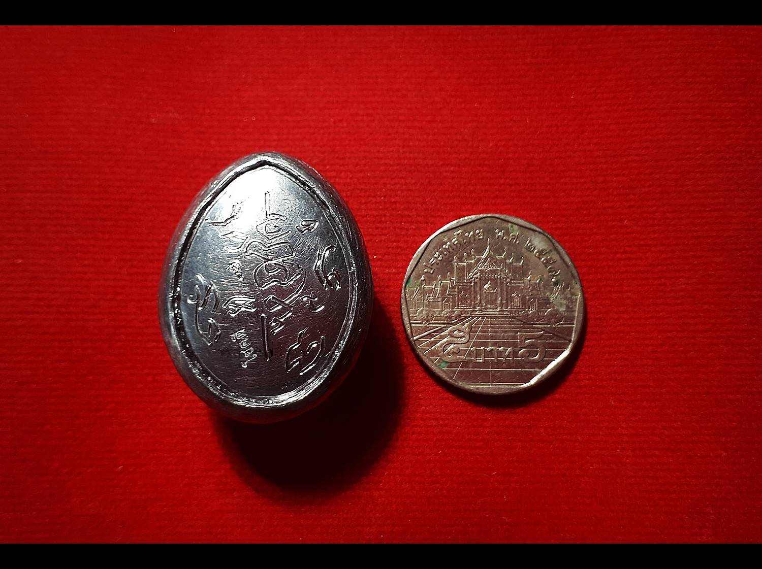 เบี้ยแก้ (เบี้ยหุ้มด้วยแผ่นตะกั่วจารเขียนอักขระด้วยมือท่านเอง) - หลวงพ่อตี๋ วัดหูช้าง (ตอกโค๊ต ต.ใบโพ และ โชคดี)